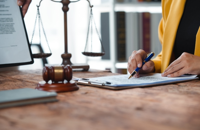 attorney reviewing legal documents with a gavel and scales of justice in the background