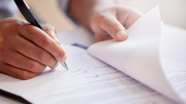 man is signing documents