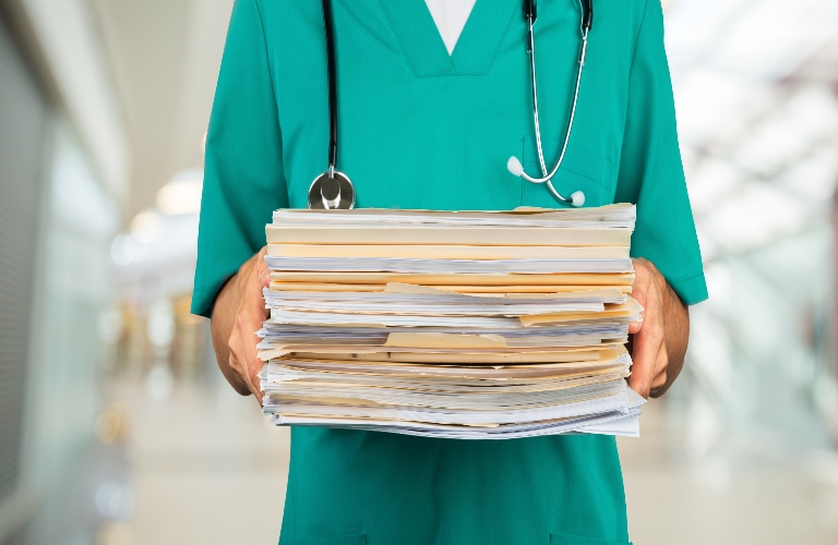 doctor holding stack of medical documents