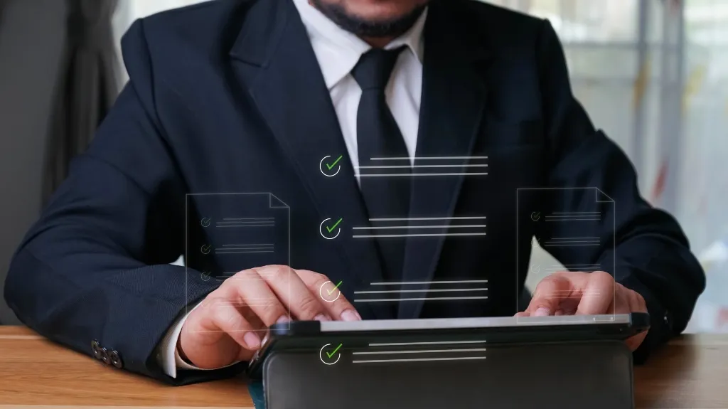 Man in black suit and tie using a tablet with floating digital checklists.